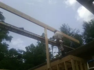 Carpenter setting a ridge beam over a new addition frame — Ice Dam Removal by Roofing Brothers in High Falls