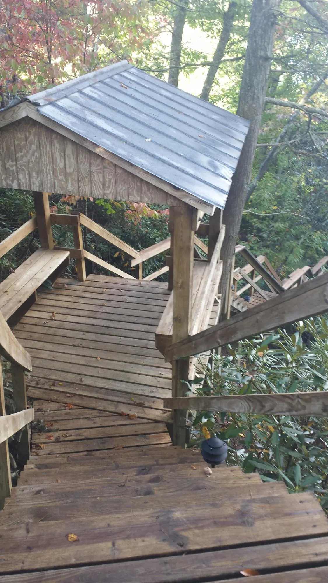 Metal roofed shelter over wooden steps on a wooded walkway — Skylight Repair & Installation work by our crew in High Falls